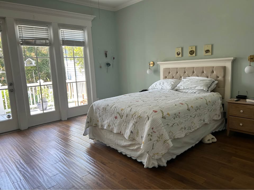 Primary bedroom with sage green walls and French doors