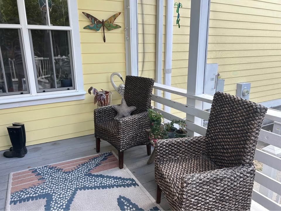 Front porch with woven wingback chairs and starfish rug
