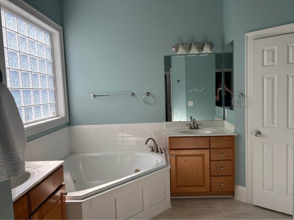 Bathroom with corner soaking tub and glass block window